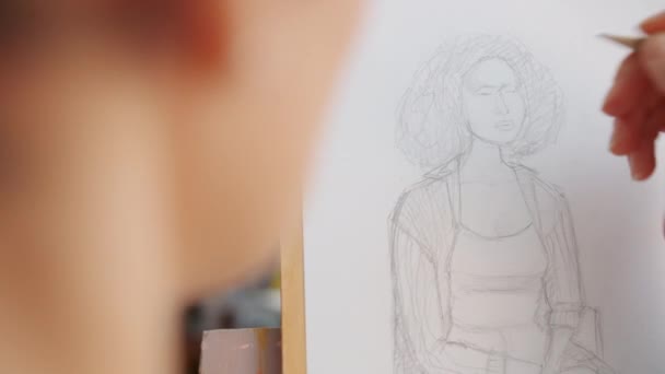 Close-up of female artists hand sketching portrait of woman in arts class — Stock Video