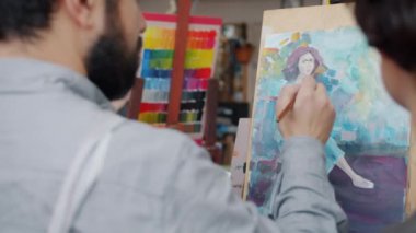 Stüdyoda kadın öğrencilere resim öğreten usta yavaş çekim.