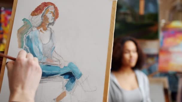 Primer plano de chicos pintando a mano retrato de chica afroamericana durante la clase de artes — Vídeos de Stock