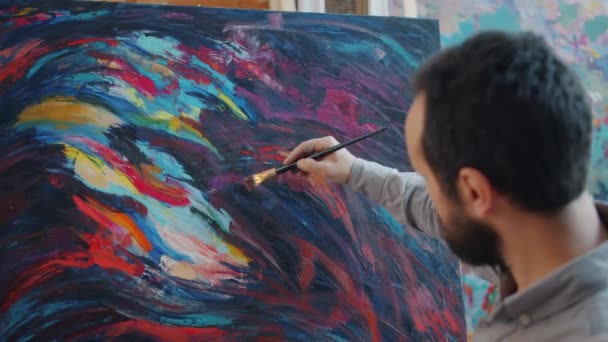 Portrait of man modern artist painting abstract picture using bright color paints — Stock Video