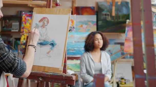 Vue arrière de l'homme et de la femme peignant des portraits de modèle de fille mixte mignon — Video