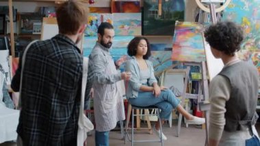 Model pozu verirken sınıfta konuşan resim öğretmeni.