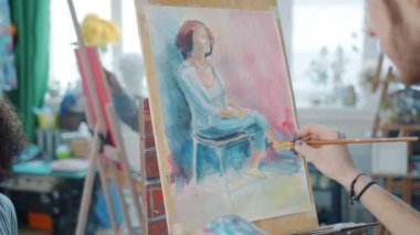 Stüdyoda erkek sanatçıya poz veren Afro-Amerikalı genç bir kızın ağır çekimleri.