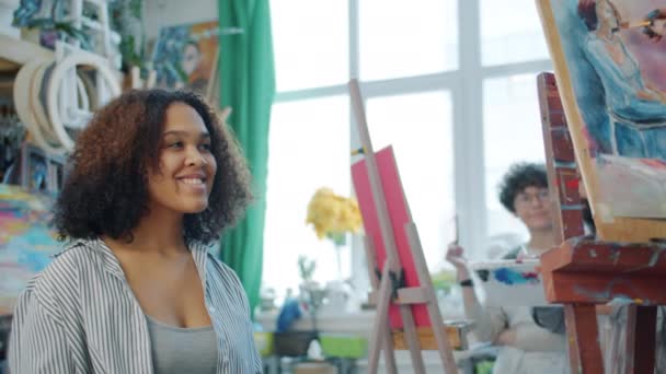 Fiatal vidám modell afro-amerikai nő pózol csoport művészeti diákok stúdióban — Stock videók