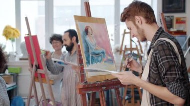 Stüdyoda Afrikalı Amerikalı bir kadının portresini yapan bir grup insan yavaş hareket ediyor.