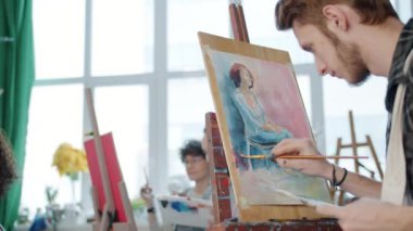 Bir grup sanat öğrencisinin öğretmeniyle birlikte Afro-Amerikan kadın modeller çizmesi yavaş bir hareket.