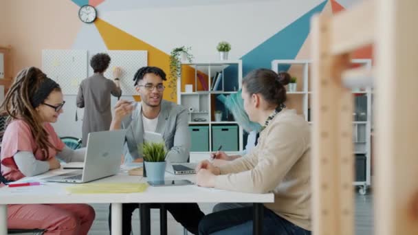 Slow motion van multi-etnische business team bespreken van werk in creatief kantoor — Stockvideo
