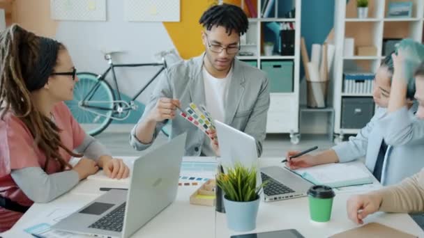 Gruppo eterogeneo di giovani designer che discutono questioni di lavoro sul posto di lavoro — Video Stock