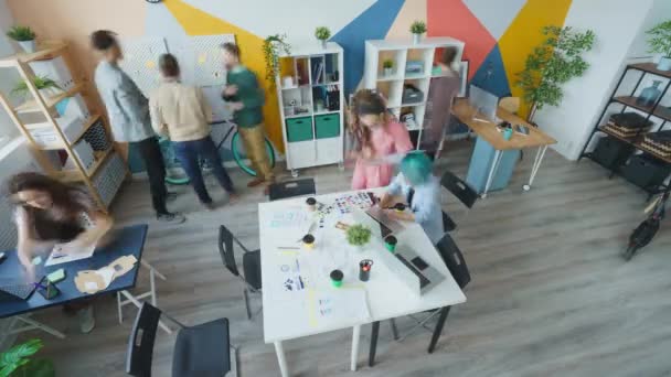 在开放空间办公室工作的年轻人同事的高视角时间差 — 图库视频影像