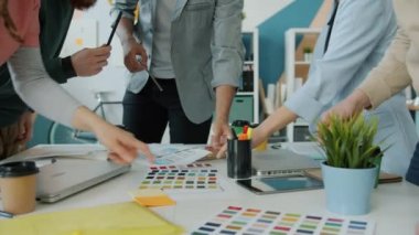 Ofiste toplantı sırasında renk paletleriyle çalışan yaratıcı tasarımcıların elleri