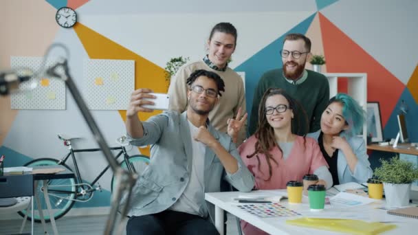 Groupe de jeunes collaborateurs prenant selfie avec caméra smartphone dans le bureau — Video