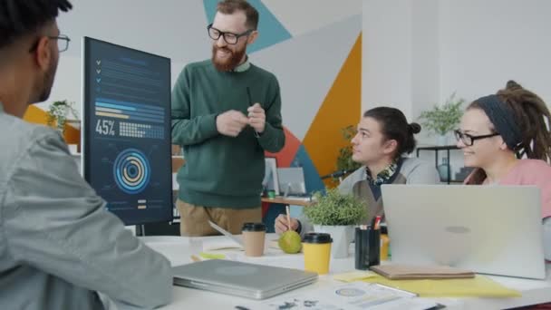 Male speaker making presentation in office pointing at digital screen with information — Stock Video