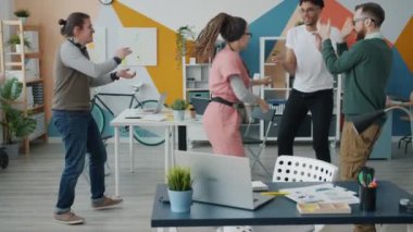 İş arkadaşları el çırparken Rastalı Kız 'ın ofiste dans etmesi.