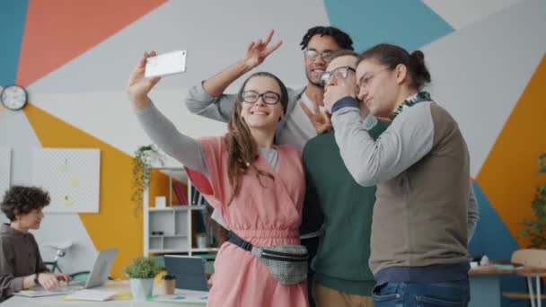 Happy young people taking selfie at work using modern smartphone camera — Stock Video