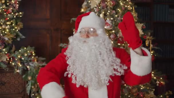 Portret van vrolijke Kerstman dansen in versierd huis bewegende armen in handschoenen hebben plezier — Stockvideo