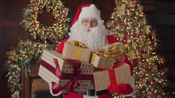 Mutlu Noel Baba 'nın portresi süslenmiş evde bir sürü Noel hediyesi tutuyor. — Stok video