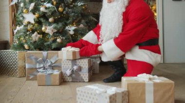 Noel Baba 'nın Noel ağacının altına hediye kutuları koyması yavaş bir hareket.