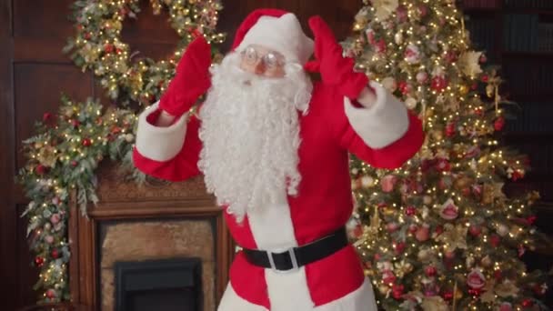 快乐的圣诞老人在装饰着圣诞树的工作室里慢慢地在室内跳舞 — 图库视频影像