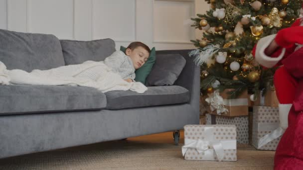 Noel Baba 'nın çocuk uyurken Noel ağacının altına hediye koyması — Stok video