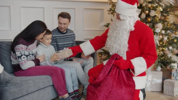 Donna, uomo e bambino bambino che ricevono regali di Capodanno da Satna Claus a casa — Video Stock