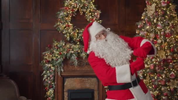 Ritratto di Babbo Natale in costume che balla in appartamento vicino all'albero di Natale — Video Stock