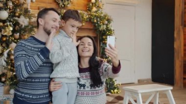 Neşeli ebeveynler ve çocuk sohbetleri yılbaşında akıllı telefon kullanarak online video görüşmesi yapıyorlar.