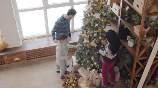 Szczęśliwa młoda rodzina dekorowanie Nowego Roku drzewa w przytulnym domu rozmowy o zabawy — Wideo stockowe