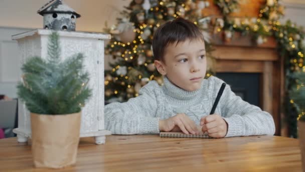 Kleiner Junge schreibt Brief an Weihnachtsmann, während Eltern vor den Winterferien Laptop benutzen — Stockvideo