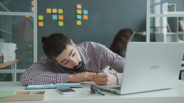 Movimiento lento del hombre árabe cansado durmiendo en la oficina y luego despertando y trabajando con la computadora — Vídeos de Stock