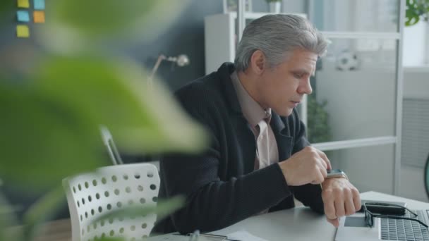 Ältere Mann berühren digitale Uhr Bildschirm und lächeln genießen Gadget im Büro — Stockvideo