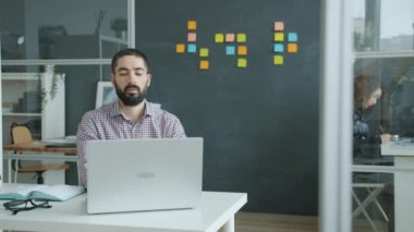Çılgın ofis çalışanı dizüstü bilgisayar kullanıyor sonra da iş sonuçlarından mutsuz olarak ayrılıyor.