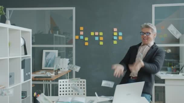 Exitoso hombre de negocios lanzando efectivo y luego bailando divirtiéndose en la oficina — Vídeos de Stock