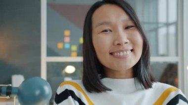 Modern ofiste gülümseyen Asyalı güzel bir ofis çalışanının portresi.