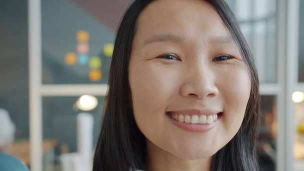 オフィスでカメラを見てかわいいアジアの女性ビジネス女性のクローズアップポートレート — ストック動画