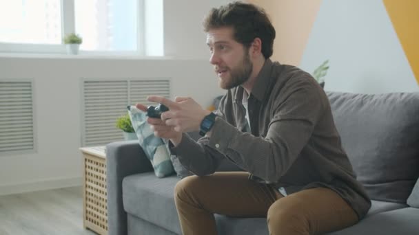 Despreocupado chico jugando videojuego presionando botones joystick divertirse en apartamento — Vídeo de stock