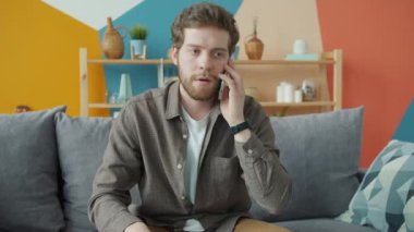 Mutlu adam akıllı telefon iletişimini seviyor evde sesli mesajları dinliyor ve kaydediyor.