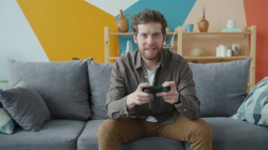 Video oyununa katılan neşeli bir gencin portresi. Kameraya bakıyor.