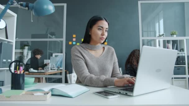 Gemengd ras zakenvrouw met behulp van laptop vervolgens masseren tempels gevoel hoofdpijn op de werkplek — Stockvideo