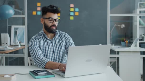 Nieszczęśliwy pracownik Bliskiego Wschodu za pomocą laptopa następnie uderzenie tabeli pięścią i opuszczenie miejsca pracy — Wideo stockowe