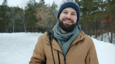 Kış günü parkta duran yakışıklı genç adamın portresi.