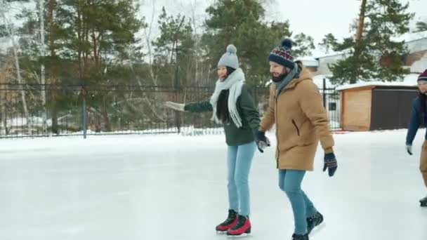 Gelukkige koppels schaatsen in het park hand in hand lachen plezier samen — Stockvideo