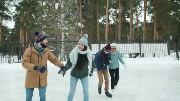 Radostné páry bruslení chatování smích těší venkovní rande v zimním parku — Stock video