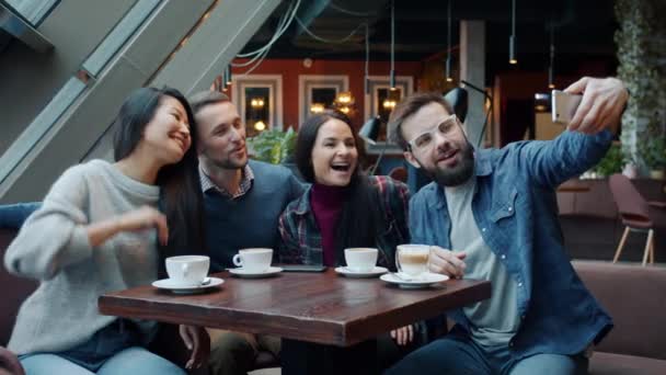 Groupe de jeunes heureux prenant selfie et s'amusant à l'aide de la caméra smartphone dans le café — Video