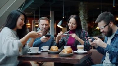 Modern gençler yiyecek ve içeceklerin fotoğrafını çekiyorlar sonra da kahkahalarla kahkahalar atıyorlar.