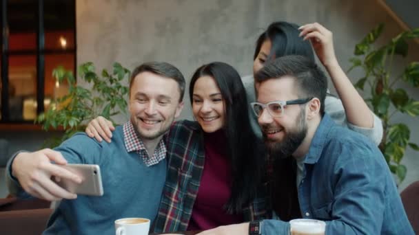 Des amis heureux prenant selfie dans un café posant s'amuser à embrasser et rire à l'aide d'une caméra smartphone — Video