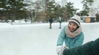 Kameraya bakarak parkta buz pateni yapan neşeli genç bayanın yavaş çekim portresi.