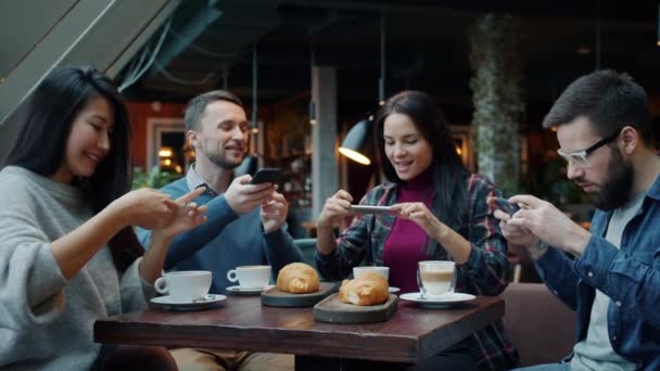 Lento movimiento de los jóvenes tomando fotos de alimentos y bebidas en la mesa en la cafetería — Vídeo de stock
