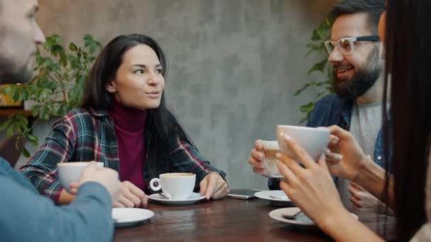 남녀 모두 커피를 두드리고 카페에 앉아 함께 웃으며 음료를 즐긴다 — 비디오