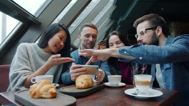 Jongeman blogger maakt foto 's van eten en drinken tijdens de lunch met vrienden — Stockvideo