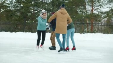 Kış parkında buz pateni yapan kadın ve erkeklerin yavaş hareket etmesi.